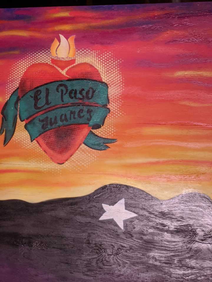 Mural of mountains during sunset. A heart floats above with a ribbon wrapped around it that reads: "El Paso / Juarez"