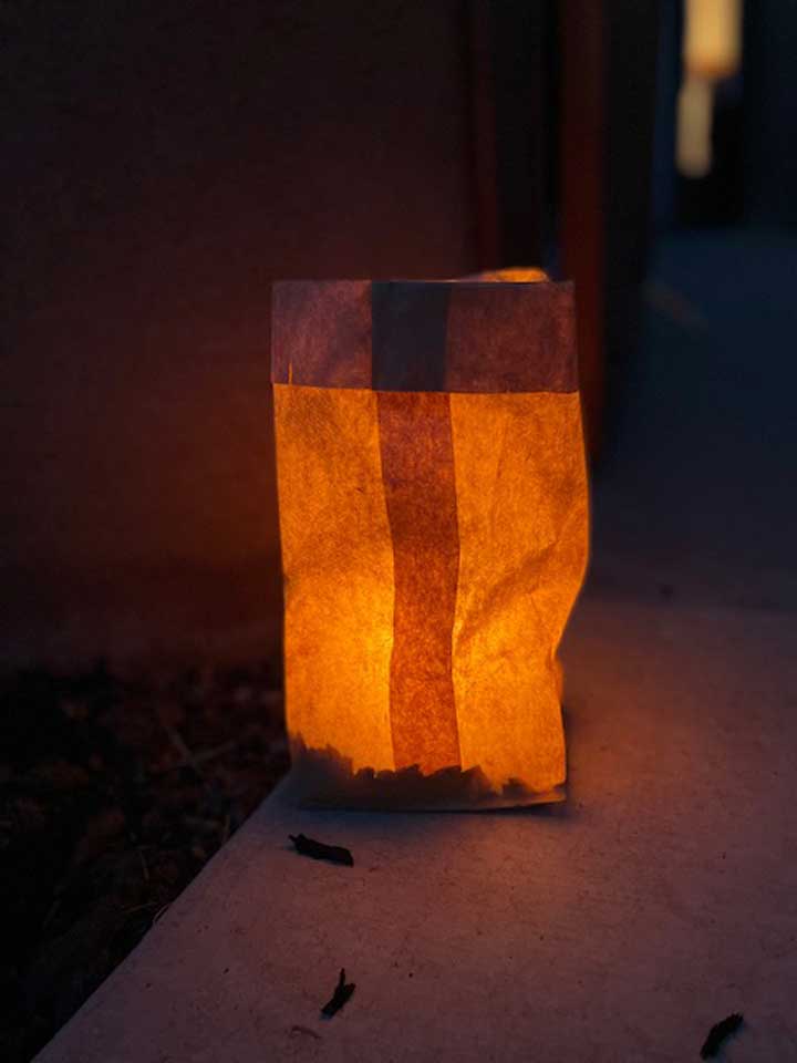 Photo of a single luminaria glowing at night