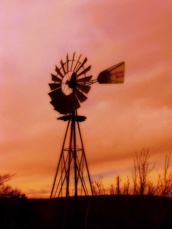 Photo of a silhouette of a windmill at sunset