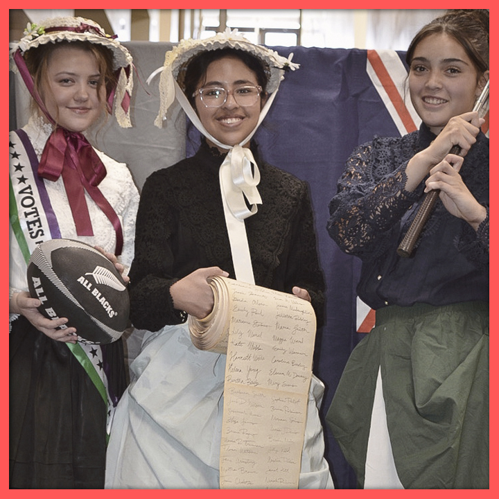 Three students dressed as suffragists