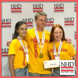 Lizzy McDonald, left, celebrates winning the History of the U.S. Marine Corps award at the national contest with her partners, Isaac Beck and Kylee Jones.