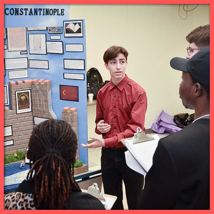 Student presenting to judges in front of an exhibit board about Constantinople