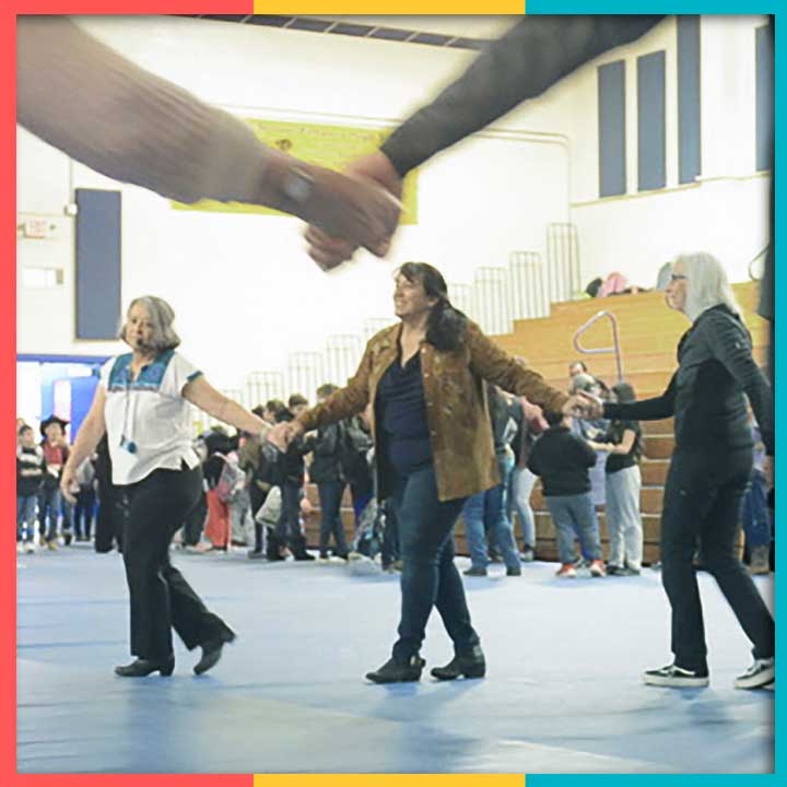 Group of people dancing in a circle and holding hands