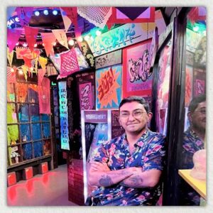 Photo of Victoriano Cardenas posing in a Meow Wolf art exhibit