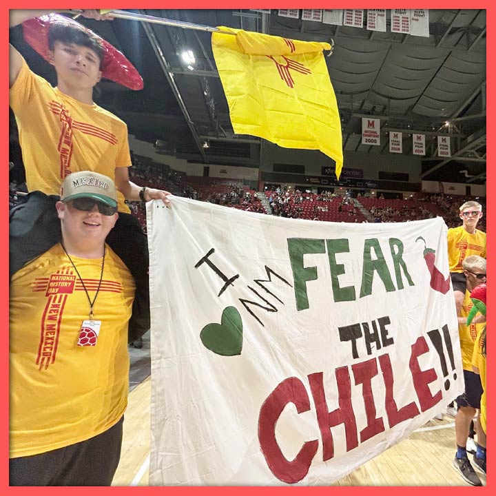 Photo of students at the NHD National Contest parade with a sign that says "FEAR THE CHILE"