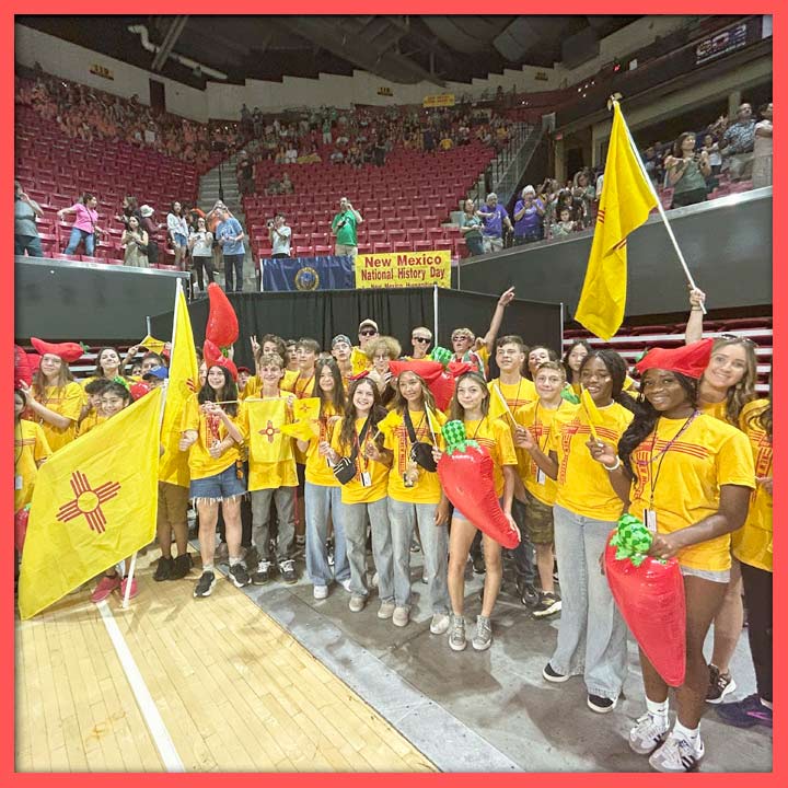 Photo of a group of NHD students with flags and inflatable chile peppers at the National contest